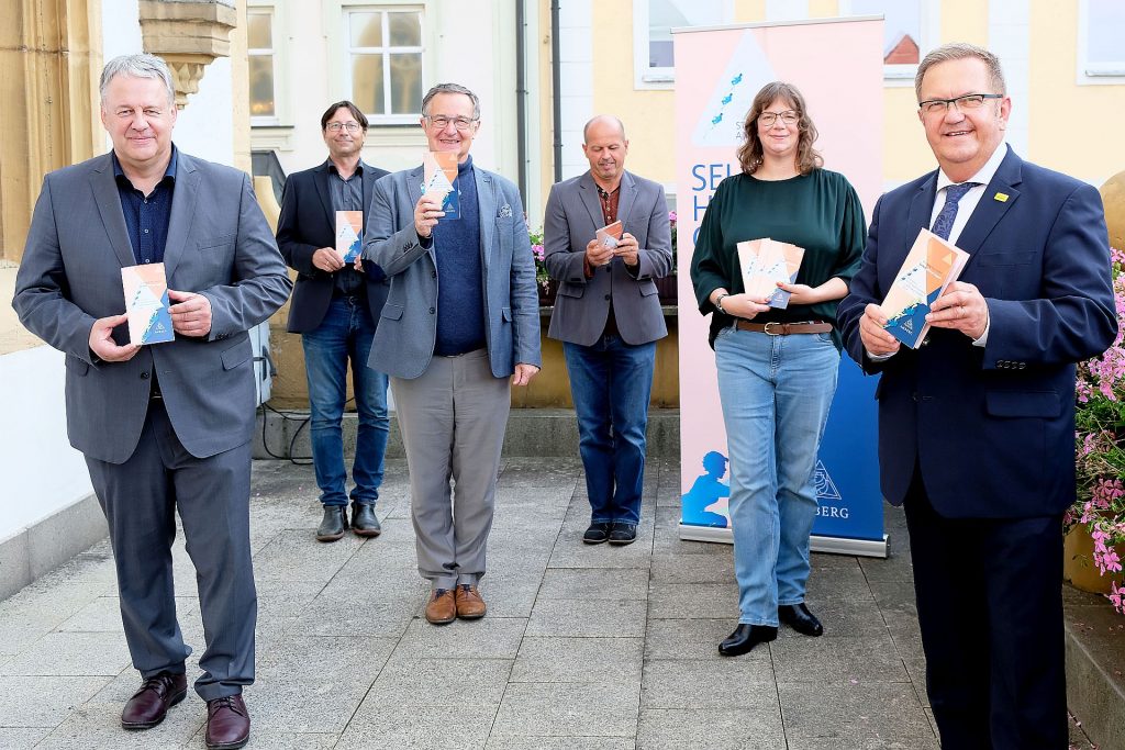 Landrat Richard Reisinger, Dr. Norbert Vogl, Dr. Harald Knerer-Brütting, Martin Reinhardt, Kerstin Bauer und Bürgermeister Martin J. Preuß (v.l.n.r.) bei der Vorstellung des neuen Selbsthilfeverzeichnisses auf dem Rathausbalkon. Foto: Susanne Schwab, Stadt Amberg