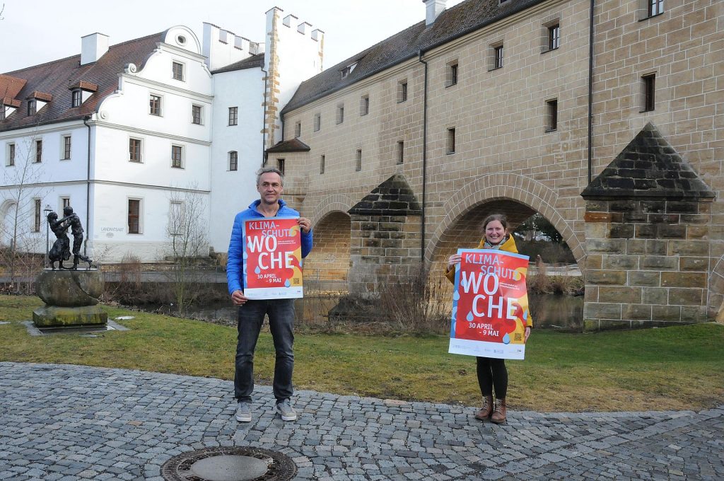 Eine Woche lang steht der Klimaschutz im Rampenlicht. Die Klimaschutzmanagerin der Stadt Amberg, Corinna Loewert, und der Klimaschutzkoordinator des Landkreises Amberg-Sulzbach, Joachim Scheid, präsentieren das Plakat mit einer Übersicht über alle Angebote zur Klimaschutzwoche. Foto: Christine Hollederer